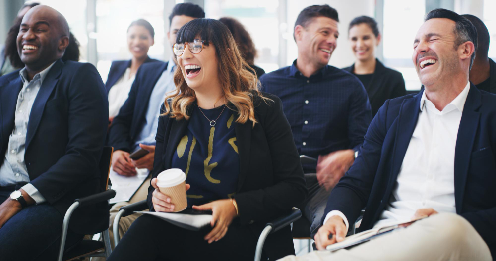Conference audience laughing during a session